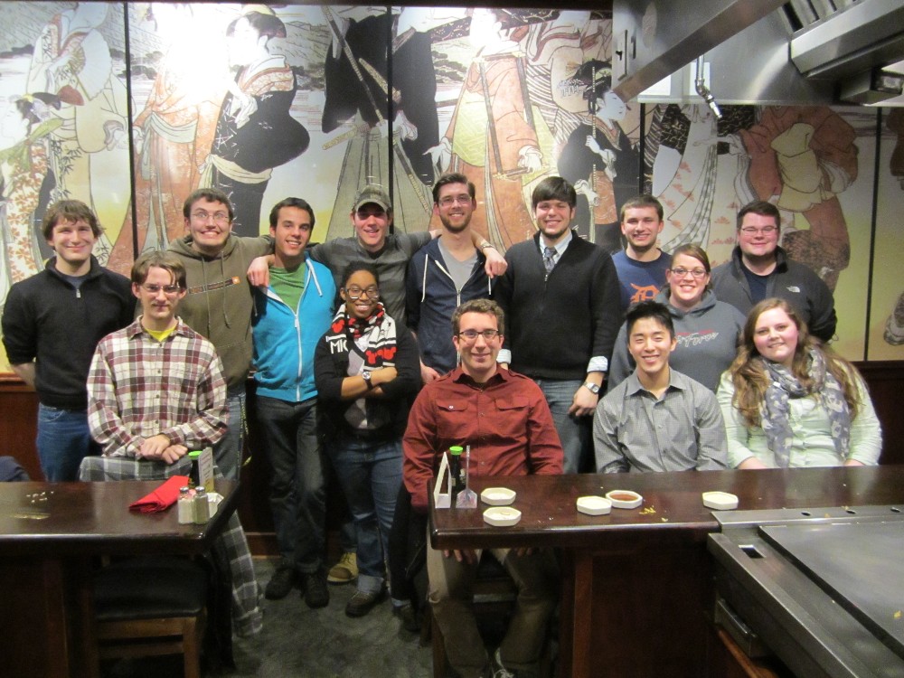 Photo of trombone students in front of a mural at a restaurant during Winter 2013.